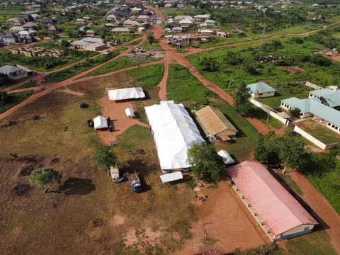 Aerial view of a temporary camp with a large white hall tent