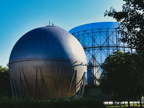 A spherical gas holder beside a gasometer frame