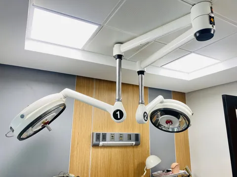 Operating theatre lights mounted on ceiling arms