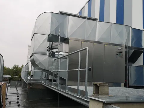 A large adsorption dehumidifier installed on a factory roof with its ductwork