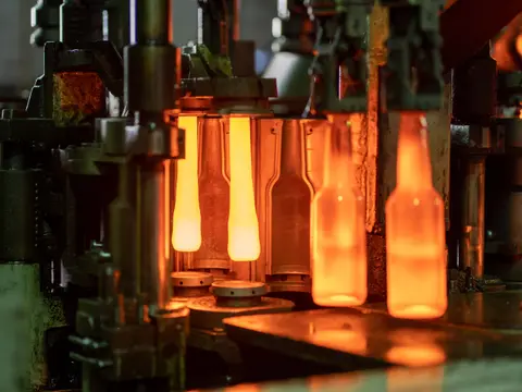 Glowing glass bottles being formed on a production machine