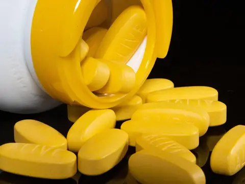 Yellow tablets spilling from a medicine bottle