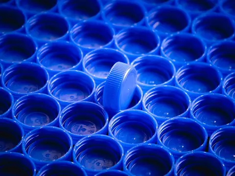 Blue plastic bottle caps in a moulded tray