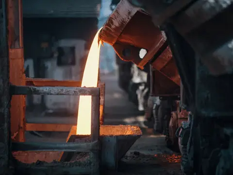 Molten metal pouring from a ladle in a foundry
